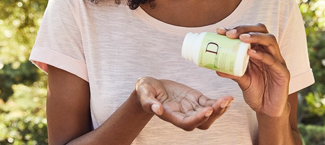 Vitamin D image - 01 black woman holding a bottle of Pharmanex Vitamin D3