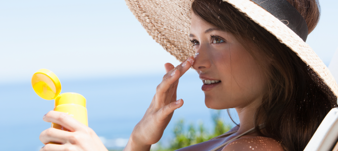 woman putting sunscreen on her face