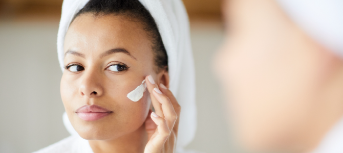 woman putting cream on her face