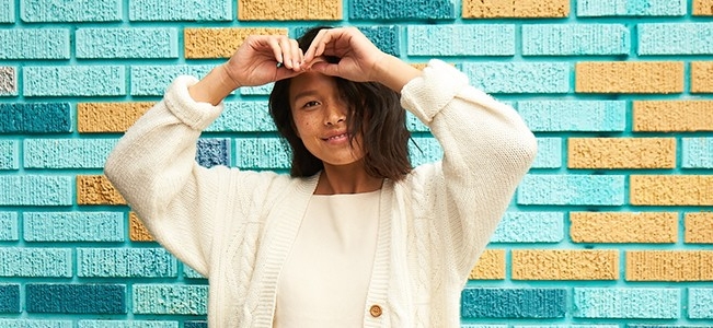 smiling girl in front of brick wall