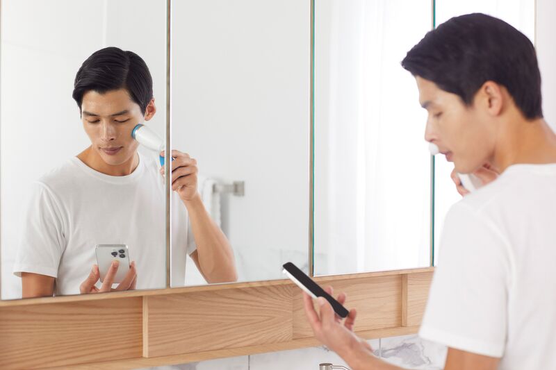 A man using the Vera app with the Nu Skin LumiSpa iO