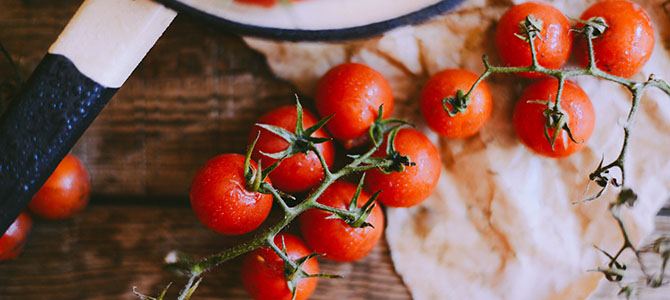 Fresh tomatoes on a vine spread out across a countertop.